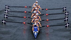 team of rowers in boat on water